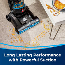 Upright vacuum floor nozzle with blue edge and brush roll, picking up debris.
