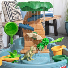 Plastic dino water table with green waterfall canopy, blue basin, and dinosaur toys