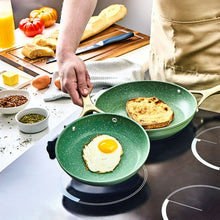 Olive non-stick skillet with two eggs cooking, long handle and speckled surface