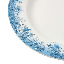 Close-up of blue floral pattern along the rim of a white ceramic plate