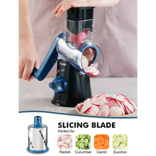 Rotary cheese grater with blue feed funnel and black base, slicing vegetables on tray