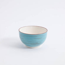 Blue ceramic dinner bowl with red rim and textured concentric ring pattern