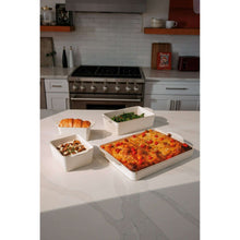 Cream ceramic bakeware set with four dishes filled with baked casserole