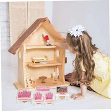 Mini wooden dollhouse play set with pink miniature furniture pieces arranged inside.