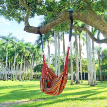 Hanging hammock chair with multicolor striped fabric suspended by red ropes