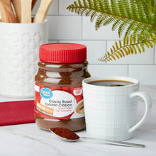 Instant coffee jar with coffee mug and spoon.
