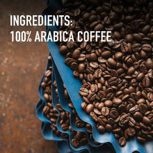 Roasted coffee beans piled in a blue scoop