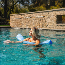 Person relaxing in a pool while holding blue patterned pool noodle floats