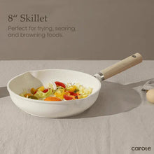 White nonstick skillet with wooden handle, filled with cooked vegetables