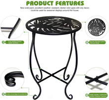 Black metal plant stand with decorative round top plate and X-shaped scroll legs