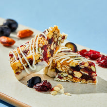 Nut bars with berry pomegranate flavor, white drizzle, nuts, and dried fruit