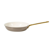 Nonstick frying pan in taupe with gold handle and white cooking surface