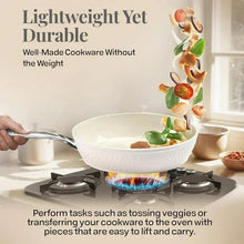 Cream nonstick frying pan on stovetop with stainless handle