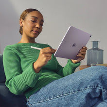 Apple Pencil Pro white stylus held while writing on a tablet