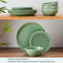Green stoneware dinnerware set with embossed leaves, stacked plates and two bowls