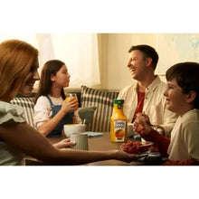 Pulp-free orange juice bottle on a dining table during a family meal