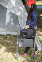 Folding director's chair with side table and black seat, outdoors