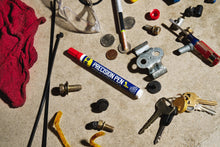 Precision pen lubricant on a workbench among small metal parts and keys