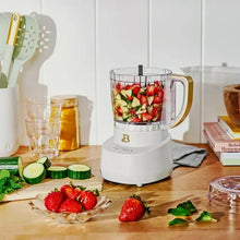 Drew Barrymore 3-cup food chopper filled with chopped strawberries and herbs in bowl