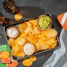 Assorted tortilla chips with bowls of green and white dip