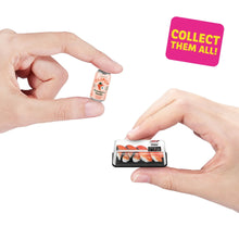 Hands unboxing a mini capsule with a small food tray