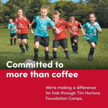 Kids wearing Tim Hortons T-shirts running on grass outdoors
