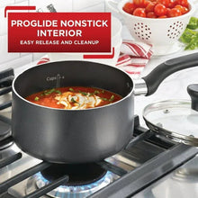 Grey nonstick saucepan on stove with black handles and cooking interior