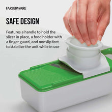 Mandoline slicer with finger guard and handle on green cutting base.