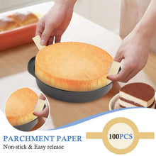 Round black cake pan with sponge cake and parchment paper liner