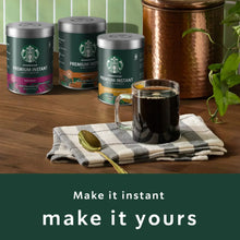 Instant coffee canisters with brewed coffee cups and a spoon on a cloth