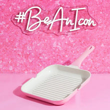 Pink ceramic nonstick grill pan with white ridged surface and long handle