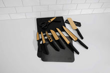 Knife set with black storage mat and assorted black-handled knives with light blades