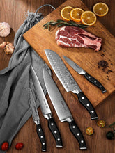 Stainless kitchen knives with black handles laid on a wooden cutting board