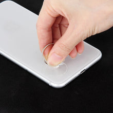 Hand removing a phone battery connector cover with a circular suction tool and pry tool