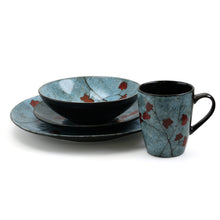 Dinnerware bowls, saucers, and mugs in blue with red floral accents and black interiors