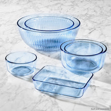 Blue tinted round storage containers and lids, empty nesting pieces