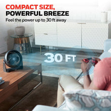 Black table fan on a wooden surface with airflow directed toward the room