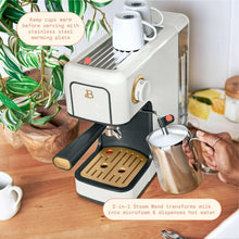 White espresso machine with steam wand and metal pitcher, countertop setup