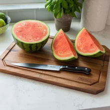 Acacia carving board with watermelon slices and black-handled chef knife