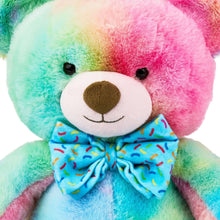 Multicolor bear plush toy close-up face with brown nose and blue patterned bow tie.