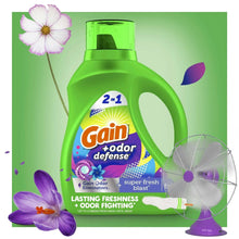 Green liquid laundry detergent bottle with floral graphics and handle cutout