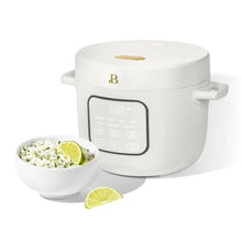 White rice cooker with lid closed and control panel, with side serving bowl and lime