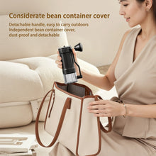 Black hand coffee grinder with detachable handle, carried in a tote bag