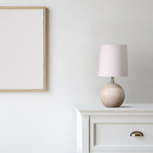 Mini table lamp with light shade and textured ball base on a white nightstand