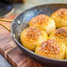 8-inch non-stick fry pan with black speckled surface, holding spiced dinner rolls