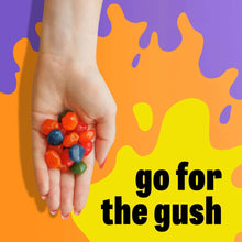 Fruit flavored snack pieces held in a hand, multicolored gel bites