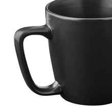 Matte black stoneware mug close-up showing curved handle and rim