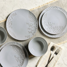 Embossed gray stoneware dinner plates with floral leaf relief in table setting