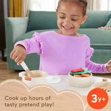 Wooden pots and pans set with pretend food and utensils on table