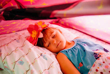 Child bed tent interior with pink fabric trim and purple star-pattern walls, sleeping area view